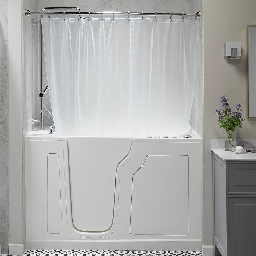 White walk-in bathtub with built-in door and curved side panel, shower curtain drawn, in a modern bathroom with a gray vanity and a vase of lavender on the counter.
