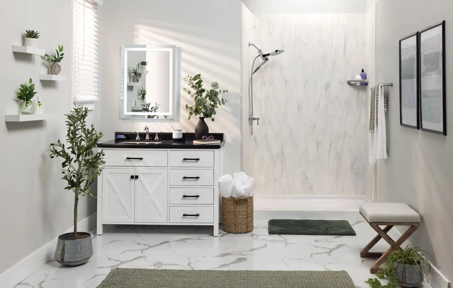 Bright, modern bathroom with a white vanity, black countertop, and a backlit rectangular mirror; potted plants on shelves add greenery.