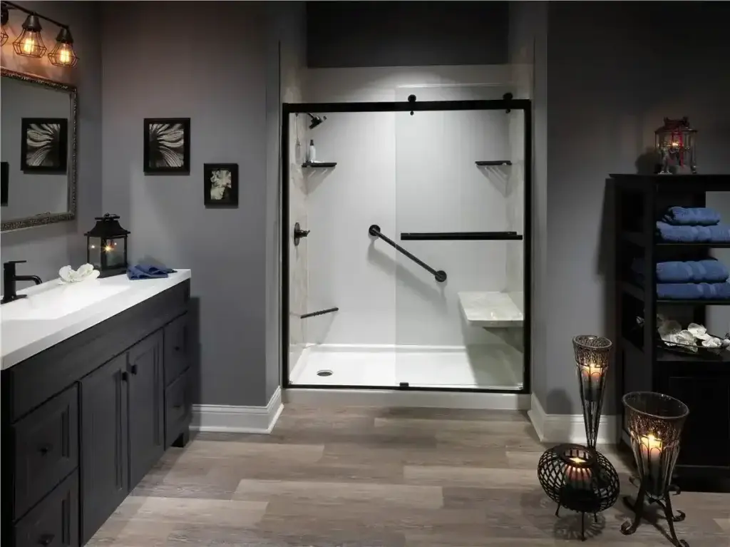 Modern walk-in shower with black framed glass enclosure, bench seating, grab bars, and dark bathroom vanity