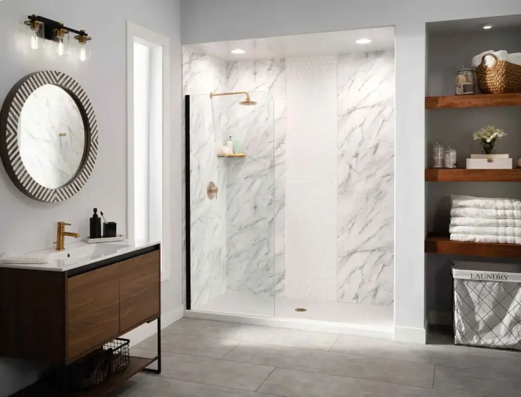 Modern walk-in shower featuring a white zero-threshold base, Calacatta marble-patterned walls with a white hexagon accent strip, brushed gold hardware, and a frameless glass splash panel.