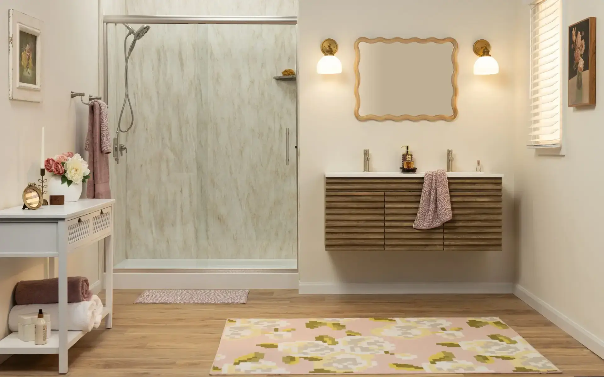 Modern bathroom with glass shower on the left, floating wooden vanity, a wavy-framed mirror, and warm wall lights.
